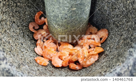 Dried shrimp being crushed in a traditional stone mortar and pestle Dried shrimp being crushed in a traditional stone mortar and pestle 140461768