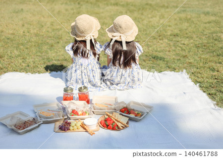 A view of two sisters enjoying a picnic in a park, and a scene of lunchtime. A view of two sisters enjoying a picnic in a park, and a scene of lunchtime. 140461788