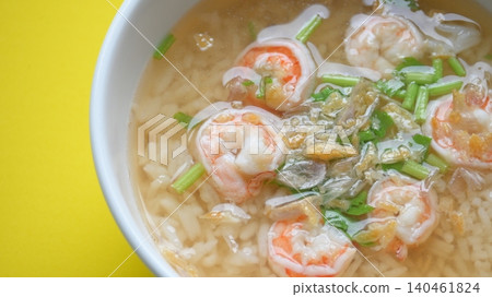 rice soup with shrimp in white bowl on yellow background rice soup with shrimp in white bowl on yellow background 140461824
