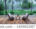 Cozy wooden deck with two armchairs and a small table on a rainy day, 3d render 140462087