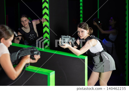 Girls play laser tag, jokingly fight with light weapons Girls play laser tag, jokingly fight with light weapons 140462235
