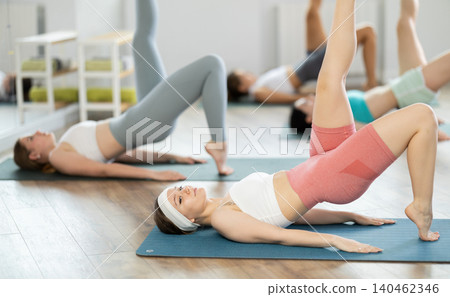 During training girl leads women class, performs variety of exercises to strengthen muscles of press During training girl leads women class, performs variety of exercises to strengthen muscles of press 140462346