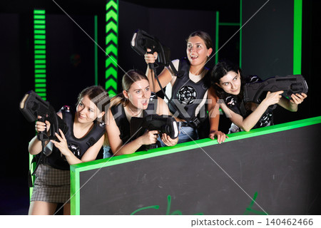 Girls play laser tag, jokingly fight with light weapons Girls play laser tag, jokingly fight with light weapons 140462466
