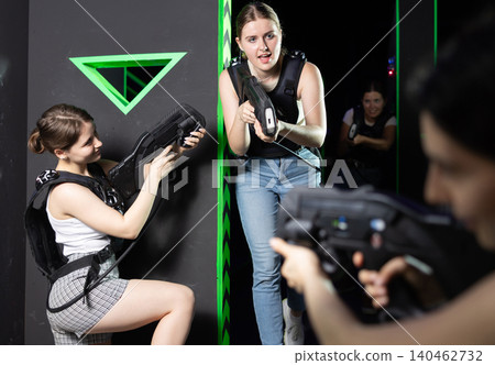 Girls play laser tag, jokingly fight with light weapons Girls play laser tag, jokingly fight with light weapons 140462732