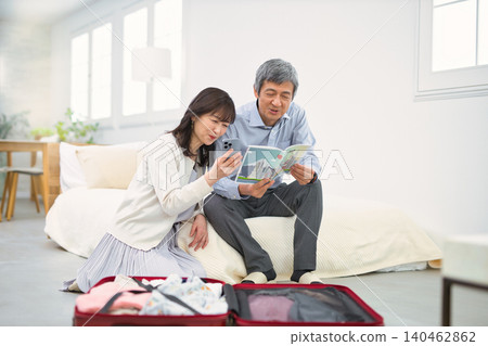 一對面帶著笑容的老夫婦正在準備旅行。 140462862