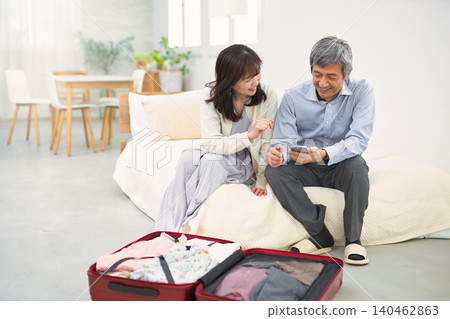 一對面帶著笑容的老夫婦正在準備旅行。 一對面帶著笑容的老夫婦正在準備旅行。 140462863
