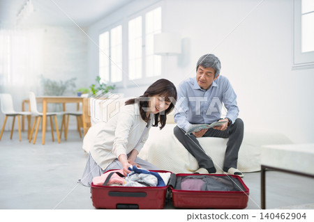 A smiling senior couple preparing for a trip. 140462904