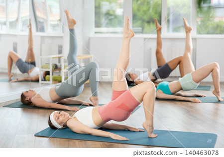During training girl leads women class, performs variety of exercises to strengthen muscles of press During training girl leads women class, performs variety of exercises to strengthen muscles of press 140463078