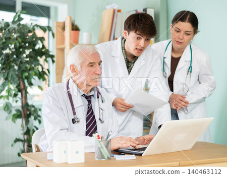 Three doctors work with laptop in clinic Three doctors work with laptop in clinic 140463112