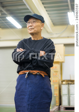 Senior working men wearing canvas aprons Senior working men wearing canvas aprons 140463597