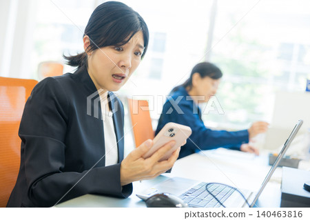 一個女人在看智能手機時感到困擾 一個女人在看智能手機時感到困擾 140463816