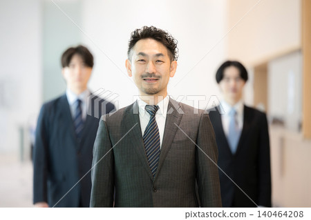 一支以男性為主的商業團隊,成員主要是經理,他們與高階主管、執行長和其他組織成員並肩站在一起,所有人都直視鏡頭。 一支以男性為主的商業團隊,成員主要是經理,他們與高階主管、執行長和其他組織成員並肩站在一起,所有人都直視鏡頭。 140464208