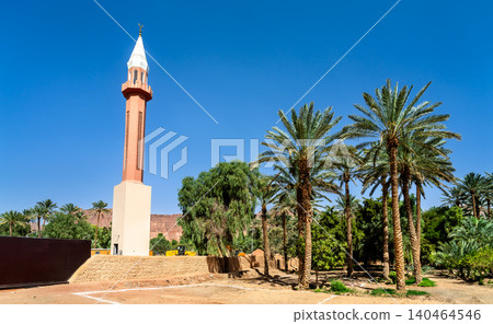 Beautiful red and white Bilal ibn Rabah Mosque minaret stands amidst lush palm trees in the historic AlUla Oasis of Saudi Arabia, under a bright blue sky. Beautiful red and white Bilal ibn Rabah Mosque minaret stands amidst lush palm trees in the historic AlUla Oasis of Saudi Arabia, under a bright blue sky. 140464546