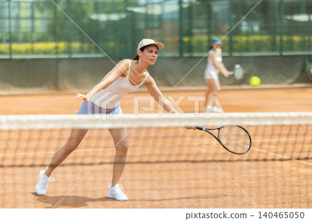 Female athlete plays tennis on open court Female athlete plays tennis on open court 140465050
