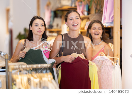 Three women choosing summer clothes in store 140465073