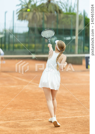 Female athlete plays tennis on open court Female athlete plays tennis on open court 140465084