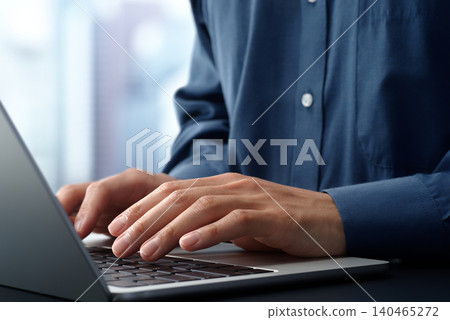 商務人士在辦公桌前使用筆記型電腦。特寫鏡頭：雙手和鍵盤。 140465272