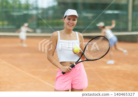 Portrait of sporty woman tennis player with racket and ball in hands Portrait of sporty woman tennis player with racket and ball in hands 140465327