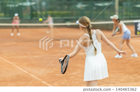 Woman playing tennis against female opponent on tennis court Woman playing tennis against female opponent on tennis court 140465362
