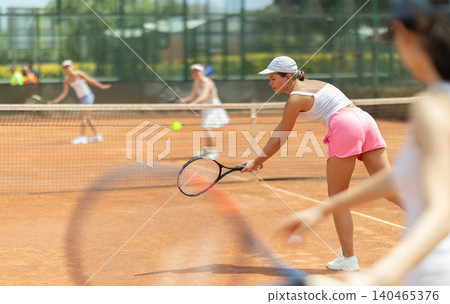 Female athlete plays tennis on open court Female athlete plays tennis on open court 140465376