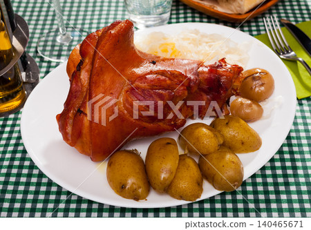 Appetizing pork knuckle and sauerkraut served with potatoes and onion Appetizing pork knuckle and sauerkraut served with potatoes and onion 140465671