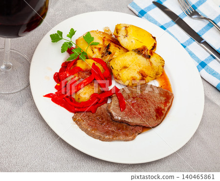 Fried veal entrecotes with potatoes and sweet pepper 140465861
