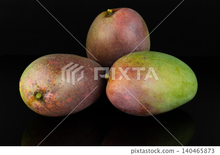 Fresh mangoes stacked on a dark surface Fresh mangoes stacked on a dark surface 140465873