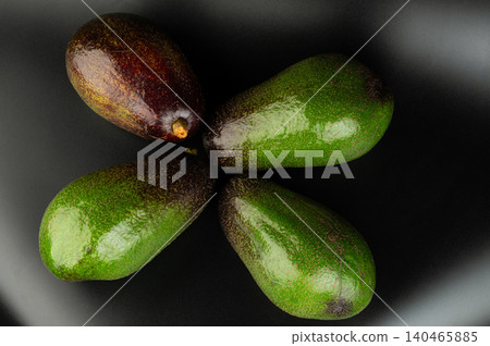 Fresh avocados arranged on a dark surface in a circle 140465885