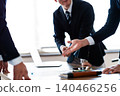 A close-up of the hands of business people pointing at the documents they have presented during a meeting. 140466256