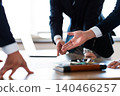 A close-up of the hands of business people pointing at the documents they have presented during a meeting. 140466257