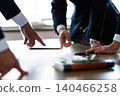 A close-up of the hands of business people pointing at the documents they have presented during a meeting. 140466258