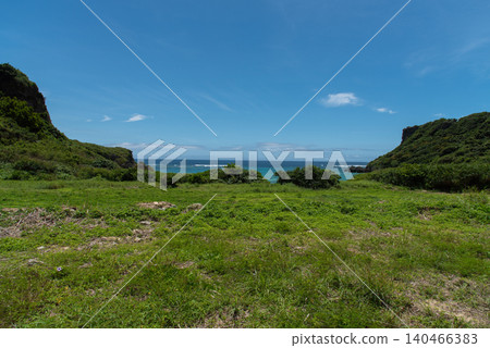 A vast green grassland and an emerald green sea. A vast green grassland and an emerald green sea. 140466383
