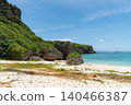 Green cliffs adjacent to the emerald green sea and white sandy beach. 140466387