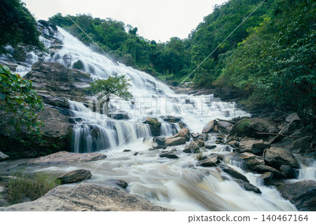 Beautiful waterfall in lush tropical green forest. Nature landscape. Mae Ya Waterfall is situated in Doi Inthanon National Park, Chiang Mai, Thailand. Waterfall flows through jungle on mountainside. 140467164