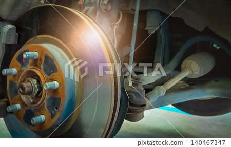 Car disc brake system. Car suspension in process of new tire replacement at garage workshop. Car disc brake mechanic check and repair. Disk break rotor. Car in change tire process at service station. Car disc brake system. Car suspension in process of new tire replacement at garage workshop. Car disc brake mechanic check and repair. Disk break rotor. Car in change tire process at service station. 140467347