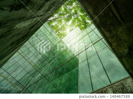Eco-friendly building in modern city. Sustainable glass office structure with integrated greenery to reduce heat and carbon dioxide. Corporate architecture. Reducing CO2 emissions. Green environment. 140467589