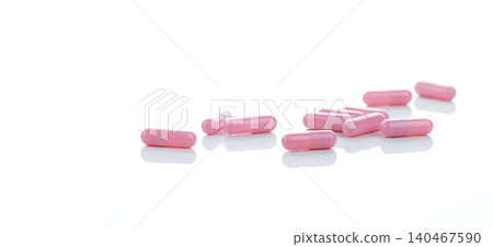 Pink capsules pill spread on white background. Prescription drug. Pharmaceutical industry. Vitamin and supplement capsule. Pharmacy store banner. Pharmaceutical industry. Healthcare and medical care. 140467590