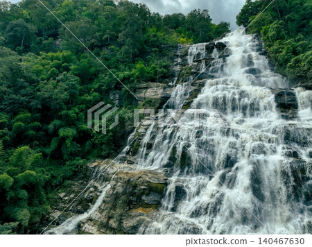 Beautiful waterfall in lush tropical green forest. Nature landscape. Mae Ya Waterfall is situated in Doi Inthanon National Park, Chiang Mai, Thailand. Waterfall flows through jungle on mountainside. Beautiful waterfall in lush tropical green forest. Nature landscape. Mae Ya Waterfall is situated in Doi Inthanon National Park, Chiang Mai, Thailand. Waterfall flows through jungle on mountainside. 140467630