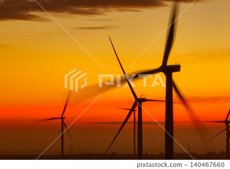 Wind farm landscape against sunset sky. Wind energy. Wind power. Sustainable and renewable energy. Wind turbines generate electricity. Green technology. Renewable resources. Sustainable development. Wind farm landscape against sunset sky. Wind energy. Wind power. Sustainable and renewable energy. Wind turbines generate electricity. Green technology. Renewable resources. Sustainable development. 140467660