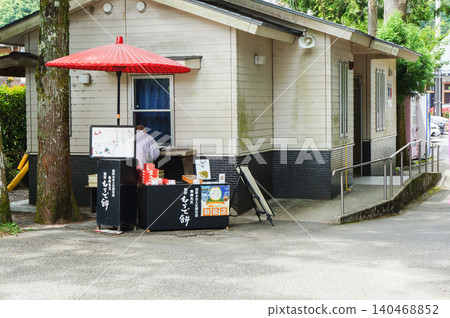 小型日式點心攤，攤位前撐著一把紅色的日式雨傘。 140468852