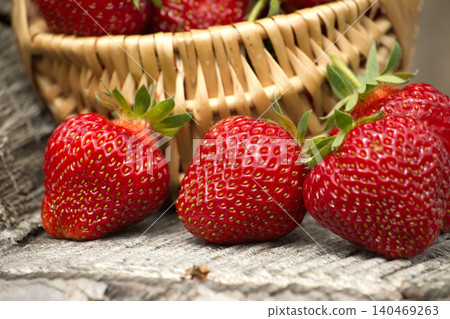Fresh Ripe Strawberries in a Wicker Basket on Rustic Wooden Table Fresh Ripe Strawberries in a Wicker Basket on Rustic Wooden Table 140469263