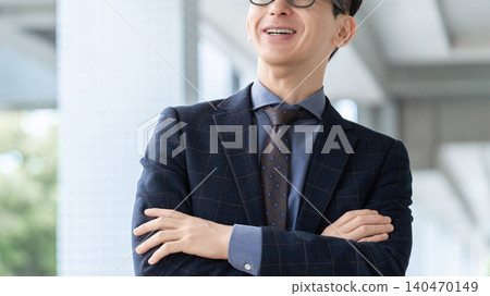 A smiling male businessman with his arms crossed. A smiling male businessman with his arms crossed. 140470149