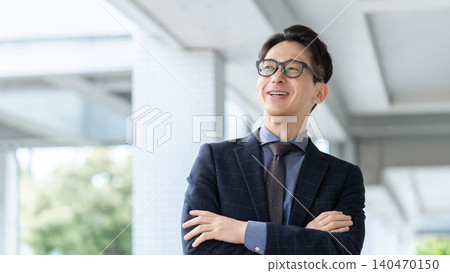 A smiling male businessman with his arms crossed. A smiling male businessman with his arms crossed. 140470150