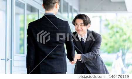 two male businessmen shaking hands two male businessmen shaking hands 140470159