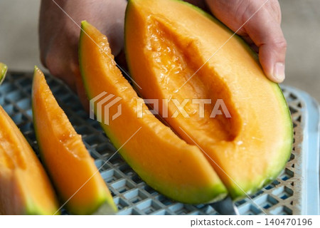 Cut Hokkaido Yubari melon - vibrant orange flesh 140470196