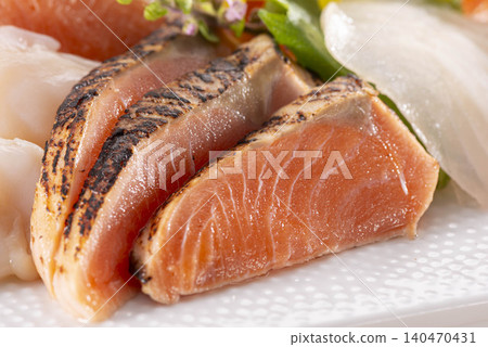 A platter of salmon sashimi with a vibrant, seared surface and white fish. A platter of salmon sashimi with a vibrant, seared surface and white fish. 140470431