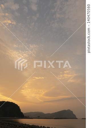 The sunset over the sea and the tranquil landscape bathed in golden light, as seen from Yoichi Town in Hokkaido. 140470560