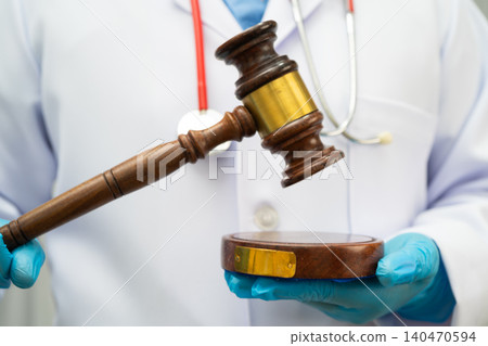 Asian doctor holding court hammer for and crime law justice, forensic medicine. Asian doctor holding court hammer for and crime law justice, forensic medicine. 140470594