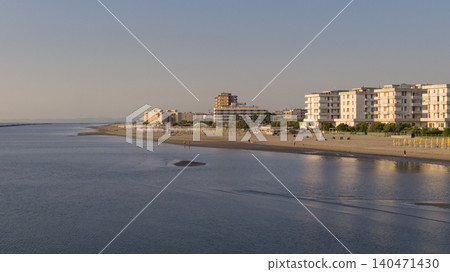 Drone view of sandy beach with umbrellas and gazebos.Summer vacation concept.Lido Adriano town,Adriatic coast, Emilia Romagna,Italy. Drone view of sandy beach with umbrellas and gazebos.Summer vacation concept.Lido Adriano town,Adriatic coast, Emilia Romagna,Italy. 140471430