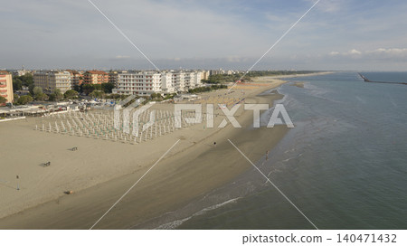 Drone view of sandy beach with umbrellas and gazebos.Summer vacation concept.Lido Adriano town,Adriatic coast, Emilia Romagna,Italy. Drone view of sandy beach with umbrellas and gazebos.Summer vacation concept.Lido Adriano town,Adriatic coast, Emilia Romagna,Italy. 140471432